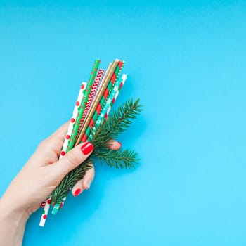New Year Christmas Xmas holiday celebration woman hand red manicure drinking cocktail party straws copy space turquoise blue color paper background minimal style. Square Template greeting card
