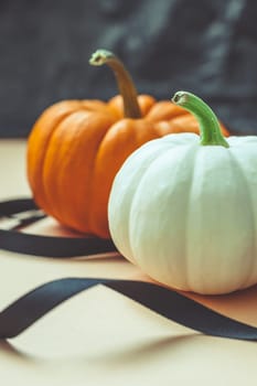 Autumn orange and white pumpkins thanksgiving halloween black ribbon background wooden box with copy space. Template for fall harvest mood text