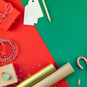 New Year or Christmas presents preparation DIY flat lay top view Xmas holiday celebration handmade gift boxes on red green paper background. Template mockup for greeting card or your text design 2019