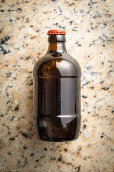 One beer bottle on a marble table. Top view.