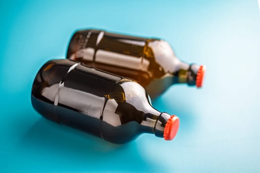 Two beer bottles on a blue background.
