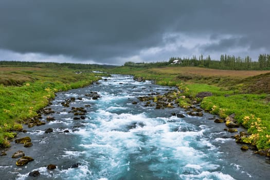 Summer Iceland Landscape with Raging River at Overcast Weather
