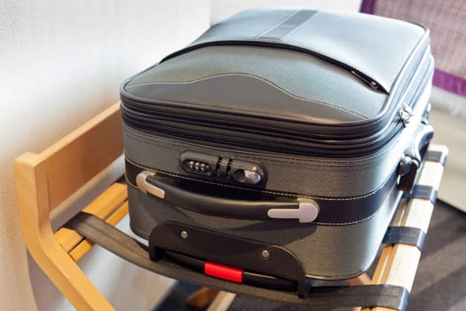 Hotel room with a suitcase on the luggage place