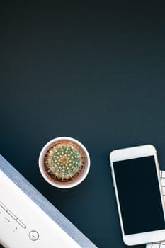 Top view flat lay of feminine desk workspace with white stereo bluetooth soundbar and smartphone for music listening with copy space on black background. Template for blog social media