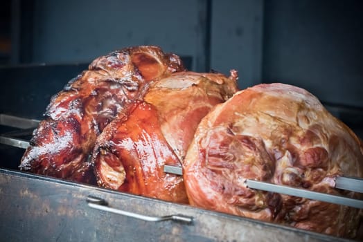 roasted pig knuckles on the spit for a big company