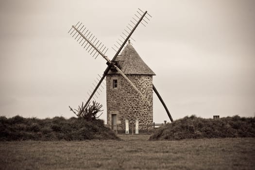Dull Landscape with Old windmill in Brittany, Western France. Toned image