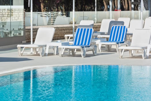 Hotel Poolside Chairs near a swimming pool. Summer shot