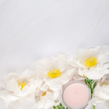 Beautiful blooming white peony flowers on marble background with copy space in minimal style, square template for postcard, text or your design. Wedding invitation and celebration greeting concept