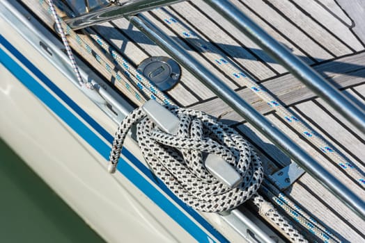 Mooring rope with a knotted end tied around a cleat on a yacht side