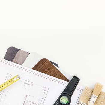 Creative flat lay overhead top view blueprint flat project plan and office supplies on decorator table workspace swatches tools and equipment background copy space concept
