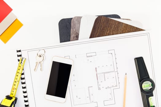 Creative flat lay overhead top view blueprint flat project plan and mobile smartphone office supplies on decorator table workspace swatches tools and equipment background copy space concept