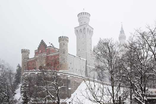 Bavarian Neuschwanstein Castle at winter snowstorm. Horizontal shot