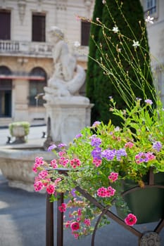 Multicolored flowerbed on a front of a stone building in France. Shot with a small GRIP