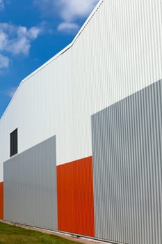 Brightly colored industrial warehouse exterior wall. Vertical shot