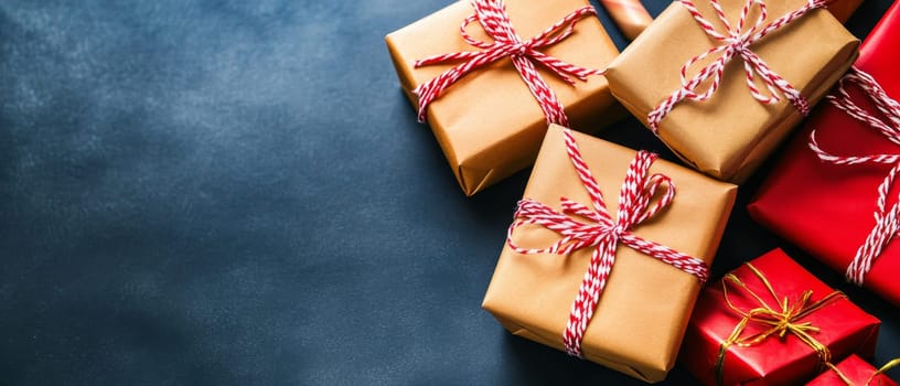 A collection of wrapped gifts with red and gold accents on a dark surface, perfect for holiday celebrations.