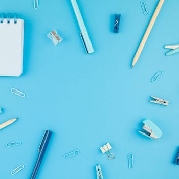 Top view flat lay of workspace desk styled design school and office supplies with copy space turquoise blue color paper background minimal style. Square Template for feminine blog social media