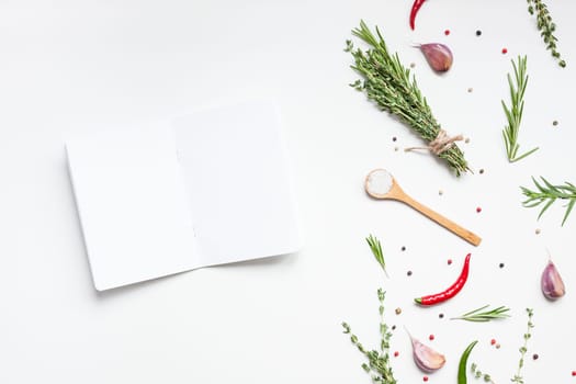 Flat lay overhead view blank notebook pages mockup text space invitation card on white background with greens herbs and spices. Menu or recipe book or food blog design with cooking ingredients
