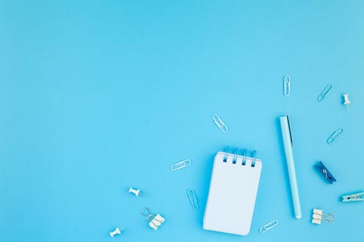 Top view flat lay of workspace desk styled design school and office supplies with copy space turquoise blue color paper background minimal style. Template for feminine blog social media