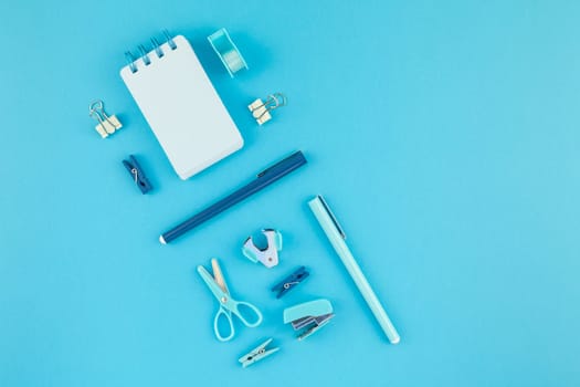 Top view knolling flat lay of workspace desk styled design school and office supplies with copy space turquoise blue color paper background minimal style. Template for feminine blog social media