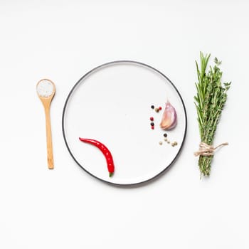 Flat lay overhead view empty plate mockup blank text space invitation card on white background with greens herbs and spices. Menu design food background with cooking ingredients