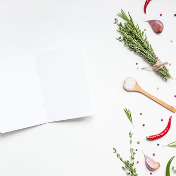 Flat lay overhead view blank notebook pages mockup text space invitation card on white background with greens herbs and spices. Menu or recipe book or food blog design with cooking ingredients