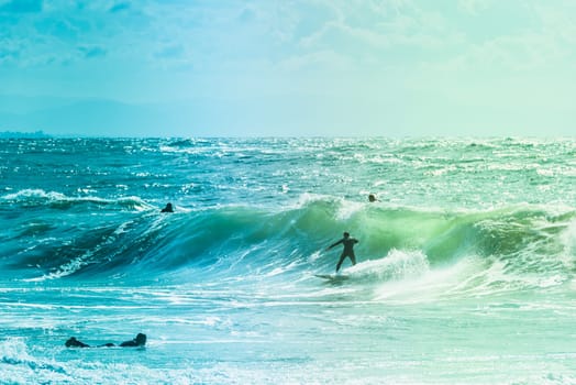 Extreme surfers riding some waves on the sea in France