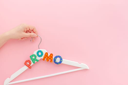 Creative top view flat lay white wooden hangers promo text pastel pink background copy space minimalism style. Template fashion feminine blog social media sale store promo design shopping concept