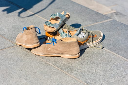 Family Shoes left on a pavement in a street. Horizontal shot