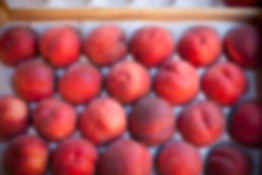 Blur shot of Ripe fresh peaches in a farmers market. Defocused