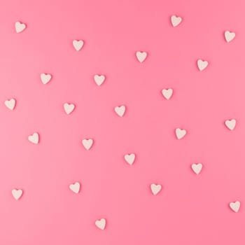 Valentines day pattern background flat lay top view of pink heart shaped candies scattered on pink square background love wedding concept