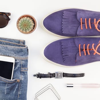 Square Flat lay of suede shoes, blue jeans, bracelets cactus and smartphone with headphones on white background with copy space. Overhead view of woman casual outfit. Trendy hipster look top view