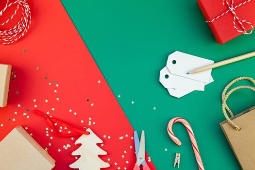 New Year or Christmas presents preparation DIY flat lay top view Xmas holiday celebration handmade gift boxes on red green paper background. Template mockup for greeting card or your text design 2019