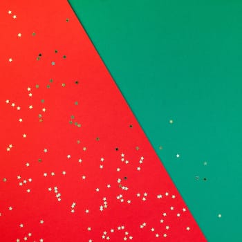 New Year or Christmas pattern flat lay top view Xmas holiday celebration red green paper golden sparkles confetti background. Template for greeting card your text design 2019