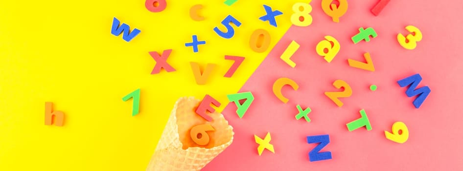 Creative flat lay back to school concept with waffle cone and welcome letters message on bright yellow and pink paper background with copy space, template for text or design. Long wide banner