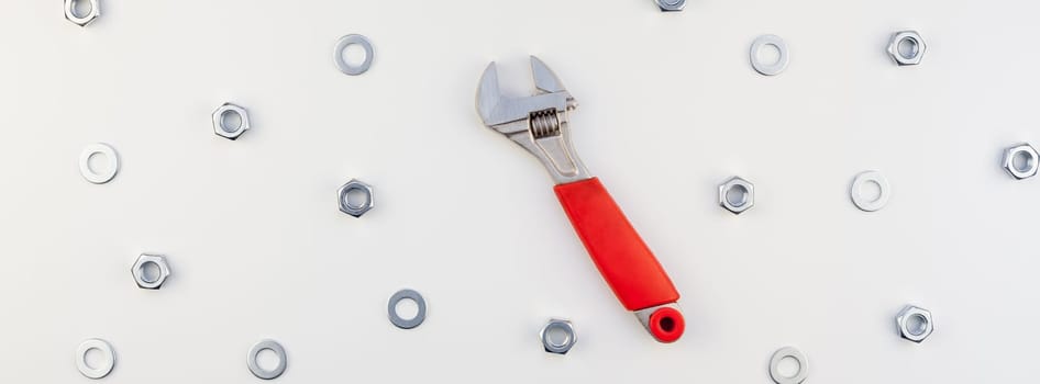 Creative long wide banner Flat lay of metal nuts and spanner on white background. Repair or improvement top view concept pattern.