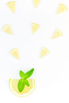 Creative flatlay overhead top view citrus lemon slices and mint herbs leaves white table background with copyspace. Hot summer refreshment lemonade concept. Beverage ingredients arranged