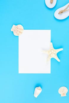 Creative flat lay concept of summer travel vacations. Top view of seashells and starfish on turquoise blue background with postcard mock up and copy space in minimal style, template for text