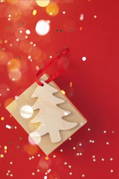 New Year or Christmas present flat lay top view Xmas holiday 2020 celebration handmade gift box red paper golden sparkles background copyspace. Template mockup for greeting card text design