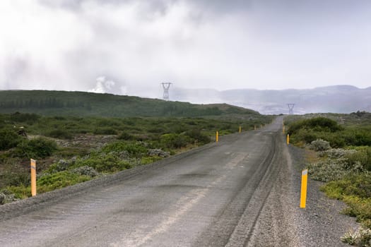 Gravel Road through Geothermal Area in Iceland. Clouds of steam