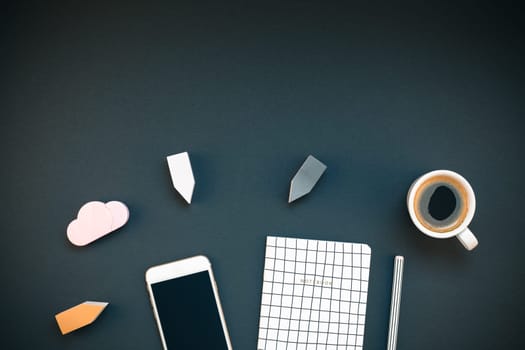 Top view flat lay feminine desk workspace with coffee, smartphone and office supplies with copy space on black background. Creative template for blog social media