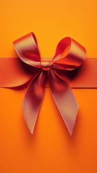 A vibrant orange ribbon bow on a solid background, perfect for gift wrapping and festive designs.