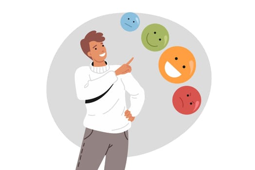 Man cares about emotional balance, pointing fingers at emoticons with different moods. Concept of importance of emotional balance for getting rid of psychological disorders and depression