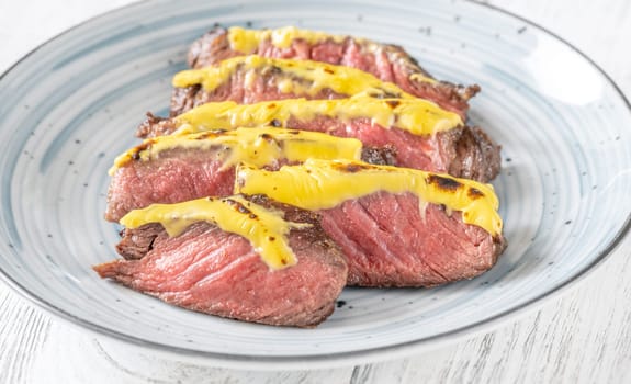 Rib eye beef steak topped with cheddar cheese