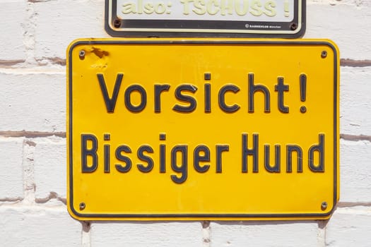 Sign Warning of the dog, Biting dog on a house wall, Germany
