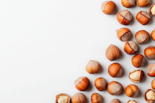 A collection of whole hazelnuts, both shelled and unshelled, is artfully scattered in the center of a white background. These nuts are perfect for baking, snacking, or garnishing dishes.