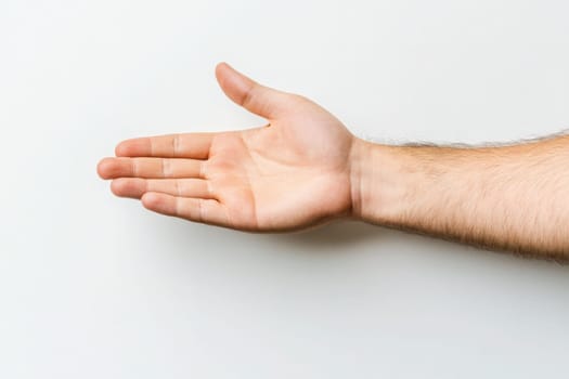 A gesturing hand extends towards the viewer, open and ready for a handshake, symbolizing partnership, cooperation, and connection on a clean white backdrop.