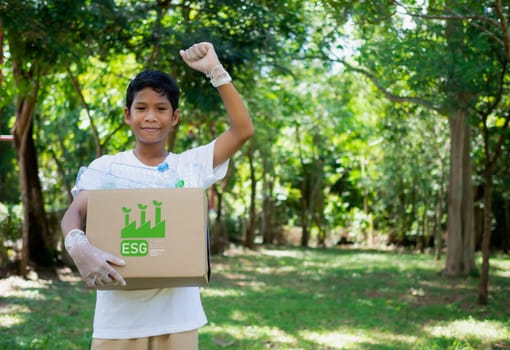 Reduction environmental pollution and recycle concept, Plastic-free, Junk food plastic packaging. Boy hold cardboard boxes for recycling and holding a recycle bin with plastic bottles in the outdoors.