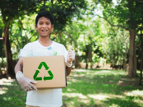 Boy hold cardboard boxes for recycling and holding a recycle bin with plastic bottles in the outdoors, Reduction environmental pollution and recycle concept, Plastic-free, Junk food plastic packaging.