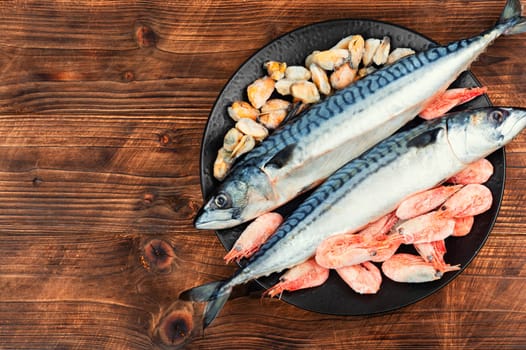 Whole raw organic fish mackerel with ingredients for cooking. Top view.