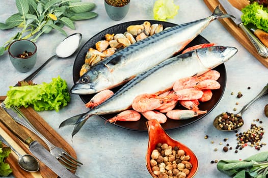 Whole raw organic fish mackerel with ingredients for cooking. Top view.